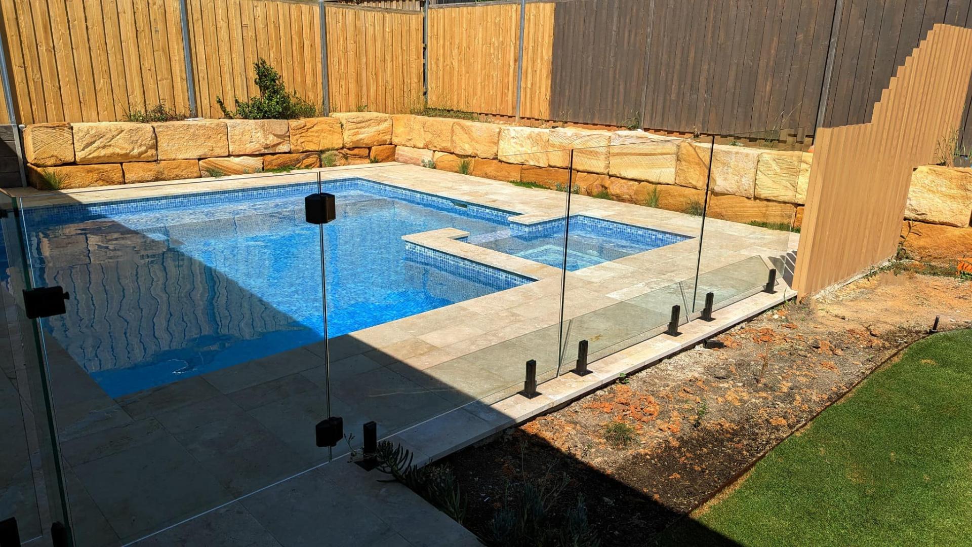 Frameless glass pool fencing with sandstone surround
